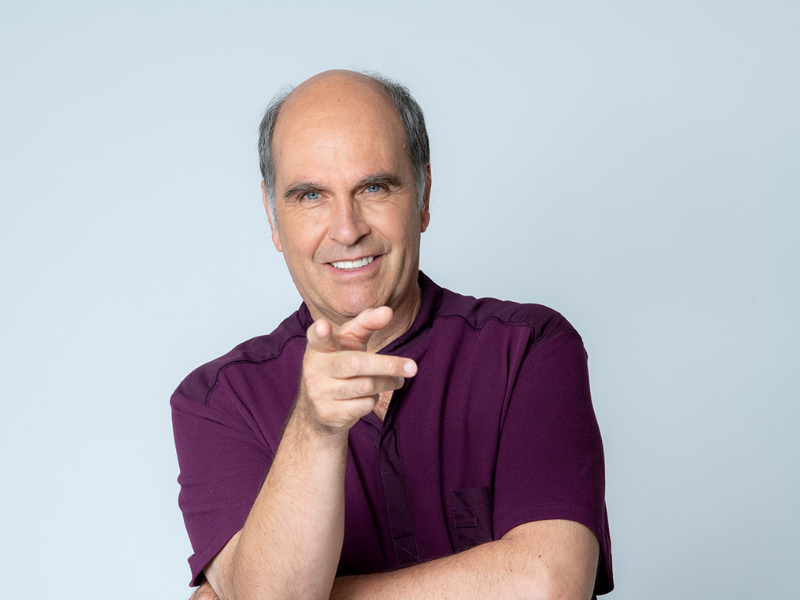 Glücklicher Mensch zeigt mit Finger in die Kamera.